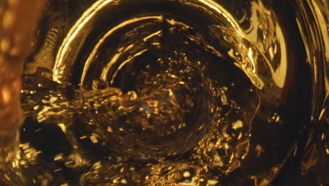 golden liquid flowing goblet closeup. golden lager beer waving inside glassware