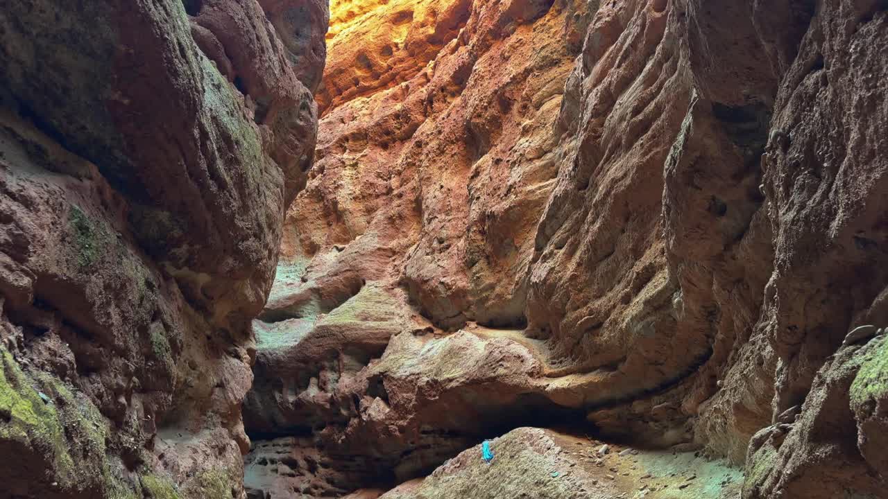 Pingshan Lake Grand Canyon, Zhangye, provincia del Gansu, Cina - Pareti rocciose ripide e consumate che si restringono verso l'alto, rivelando texture brillanti e motivi di erosione illuminati dalla luce solare dall'alto - Inquadratura inclinata