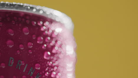 close up of condensation droplets on revolving takeaway can of cold beer or soft drink against yellow background with copy space 3