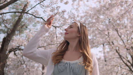 lovely young woman enjoying the view of lush sakura flowers at yangjae citizen's forest park, seocho district, seoul city, south korea