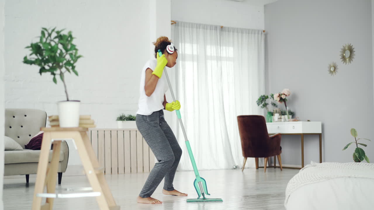 Woman Cleaning Her Home While Dancing to Music