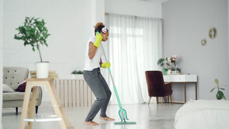 woman cleaning her home while dancing to music