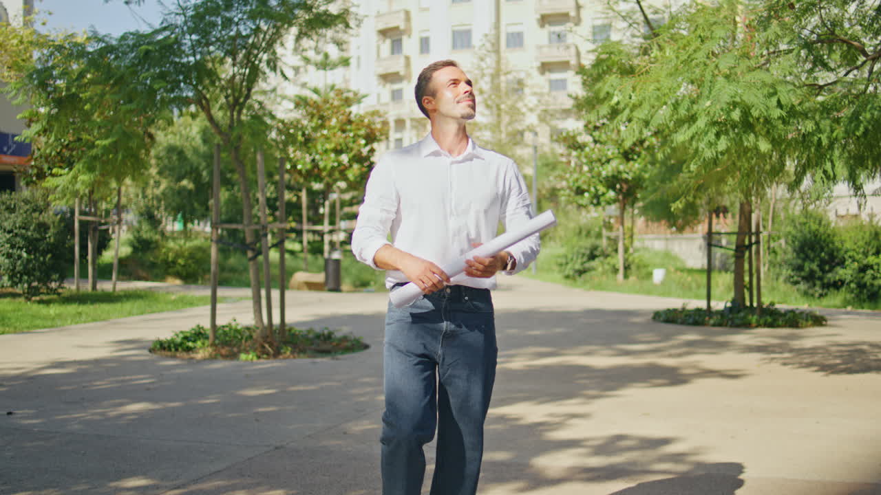 Man architect inspecting building area strolling sunny street. Boss walking