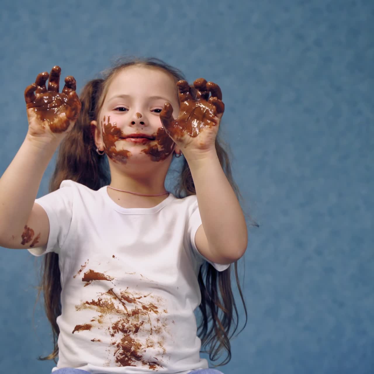 . Portrait of girl with chocolate. Small girl with chocolate smeared all over her face and fingers
