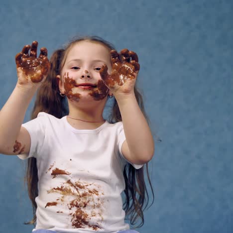 . portrait of girl with chocolate. small girl with chocolate smeared all over her face and fingers