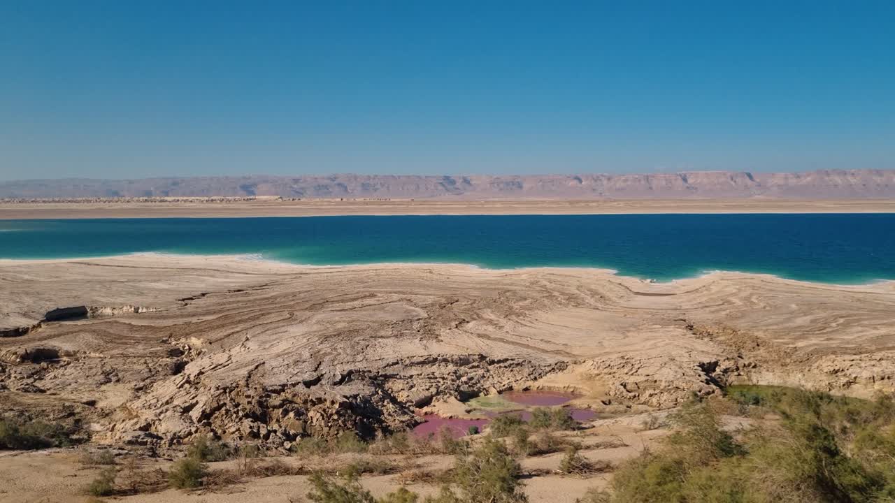 Ürdün’deki Ölü Deniz’in geniş panoramik görüntüsü; iklim değişikliği ve yoğun tarımsal faaliyetin neden olduğu çevresel değişiklikleri gözler önüne seren, çekilen kıyı şeridini gösteriyor
