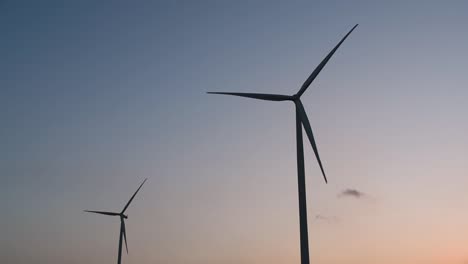 wind turbines silhouette against the blue-sky during sunset, clean alternative energy in thailand and mainland southeast asia