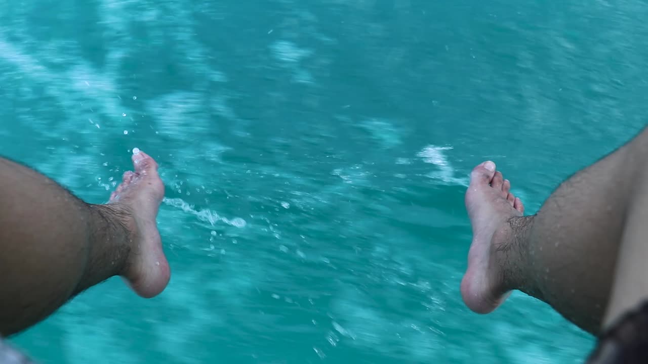 Piedi che schizzano sull'acqua turchese mentre si è in barca