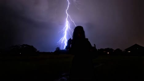 woman in a field during a thunderstorm with lightning