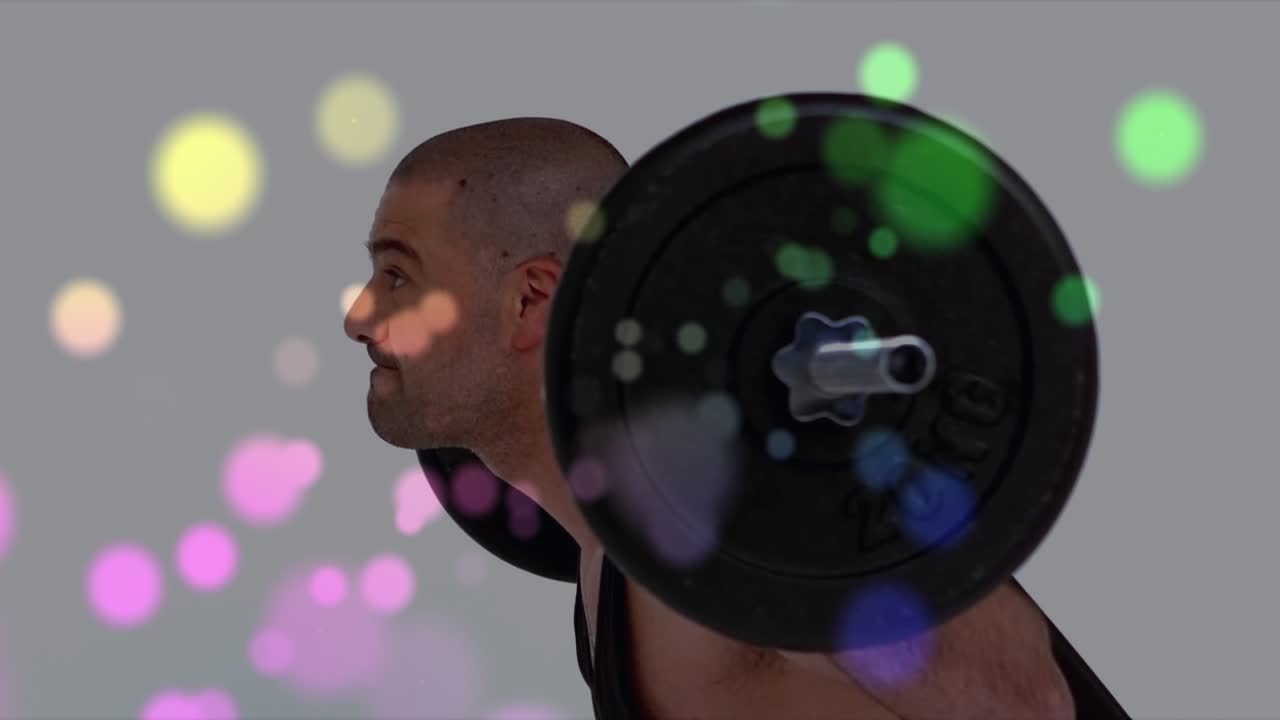Male lifter starting bent shifting torso upright holding barbell for training bokeh obscuring body