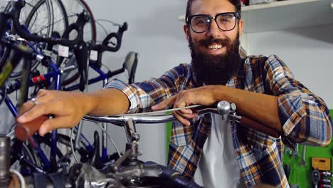 portrait of mechanic with bicycle in workshop