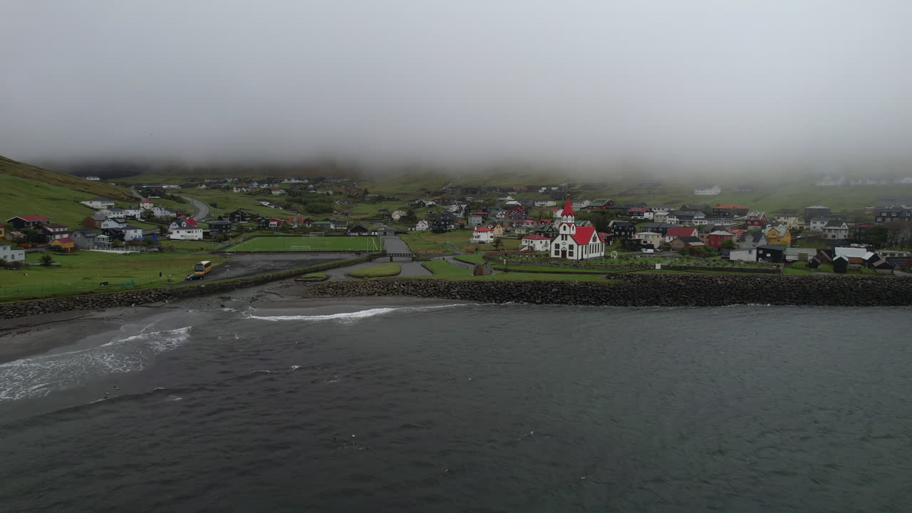 aldea de sandavagur, isla de vagar: vista aérea que viaja a la aldea y la iglesia en las islas feroe