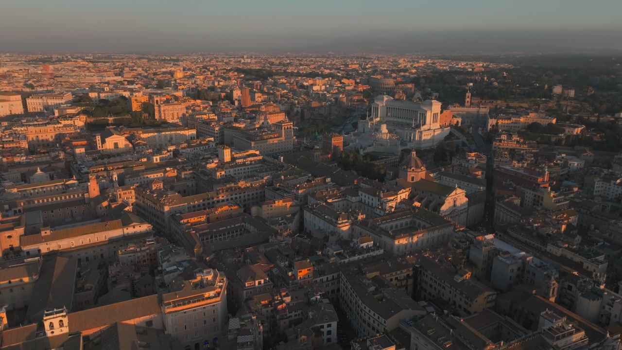 Sunset casts a warm glow over Rome's iconic historic buildings and sprawling urban landscape.