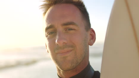 portrait of a surfer holding his surfboard ready