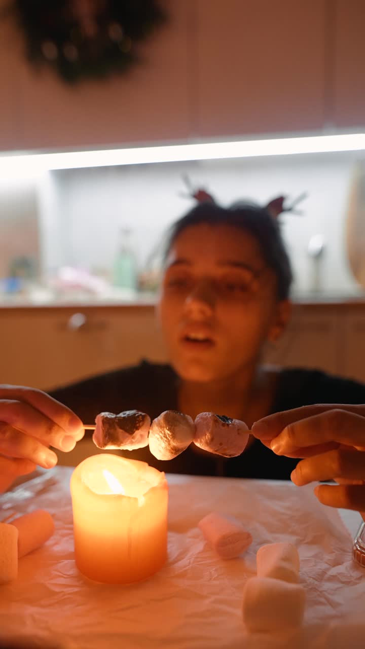 Woman roasting marshmallows over a candle