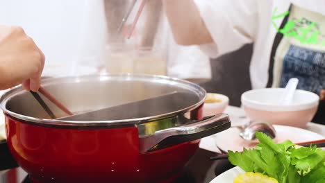 friends cooking and sharing hotpot together