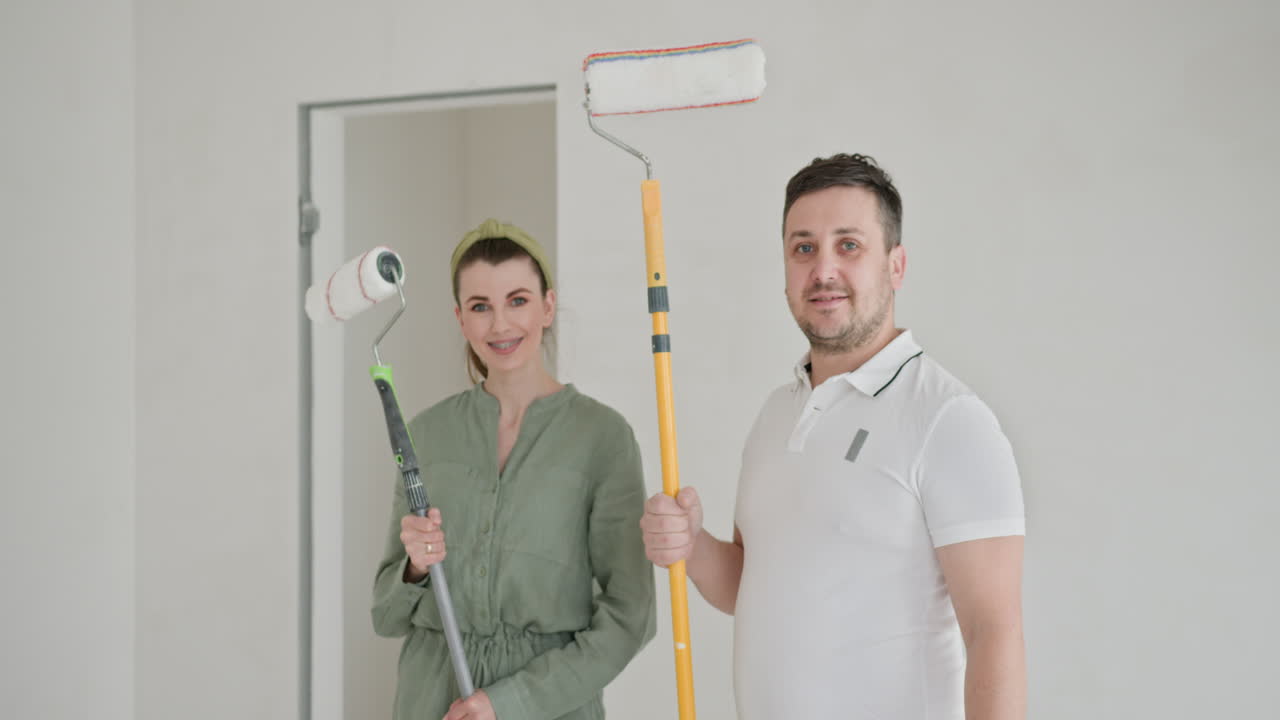 pareja pintando paredes interiores