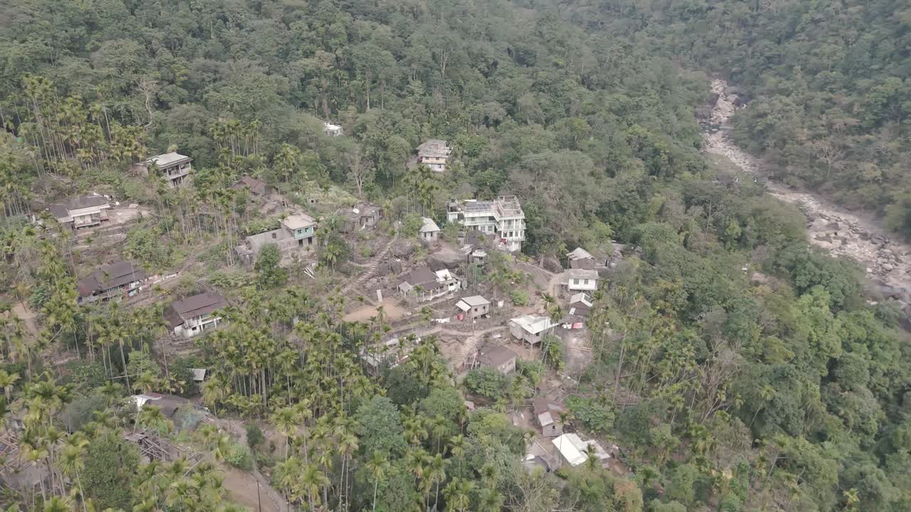 Top-down aerial view of the remote Nongriat village, nestled deep in a lush jungle valley near the Double Decker Root Bridge in Meghalaya, India