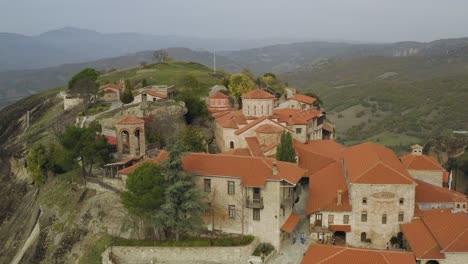 vista aérea de los turistas que caminan dentro de los monasterios de meteora, en la soleada grecia - aumento, disparo de drones