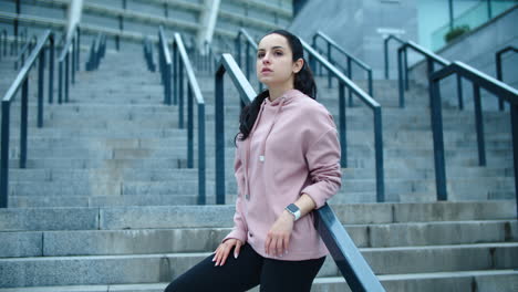 Fitness-woman-relaxing-on-staircase-outdoor.-Young-female-model-posing-on-stairs