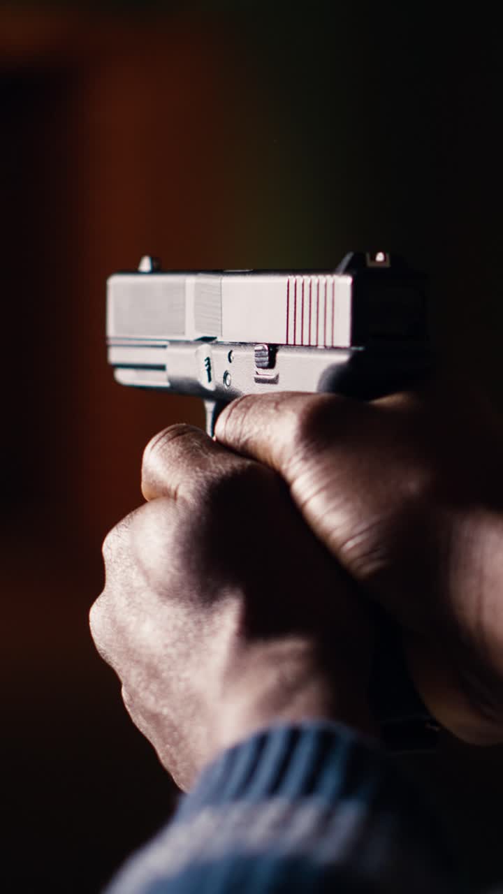 Vertical video Shooting range client shoots with pistol, engaging targets, close up