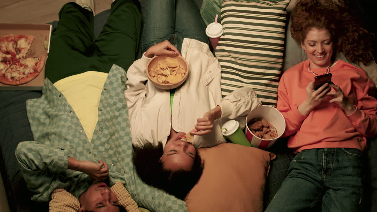 세 명의 친구들이 소파에서 휴식을 취하고 있습니다.