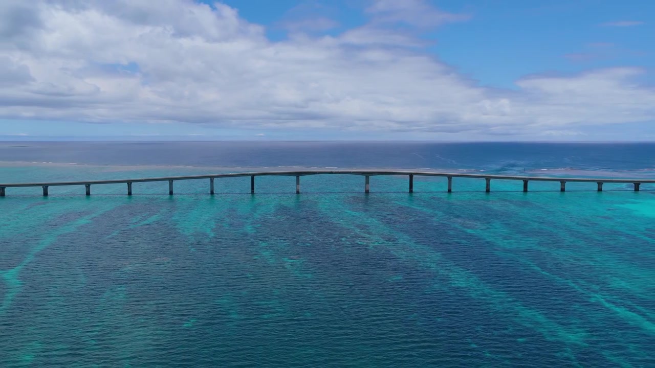 Inquadratura orizzontale con carrellata a destra, mantenendo il fuoco su un punto fisso nell'inquadratura, che mostra il ponte di Kurima Island e le acque turchesi a Miyako, Okinawa, Giappone