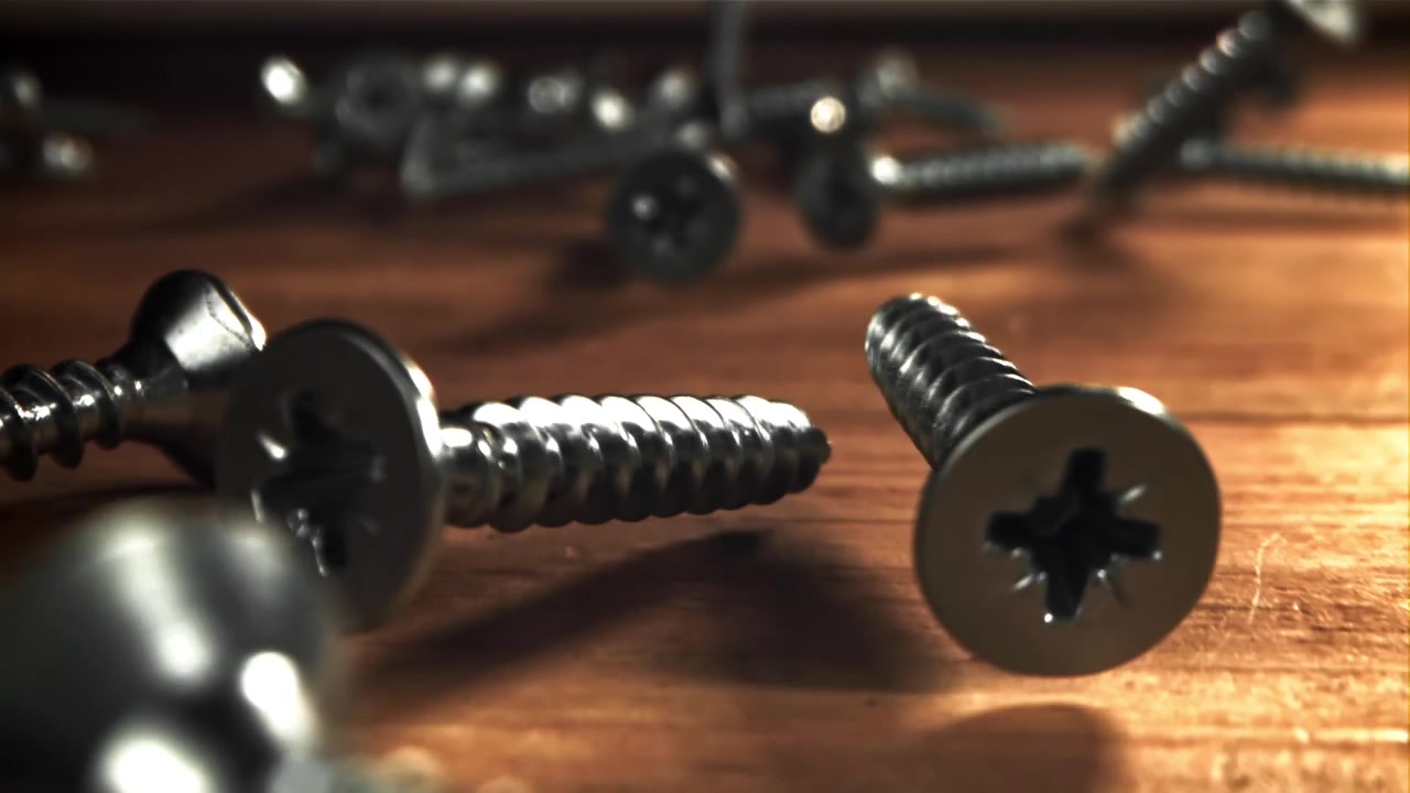 Metal Screws Falling and Scattering on a Wooden Surface