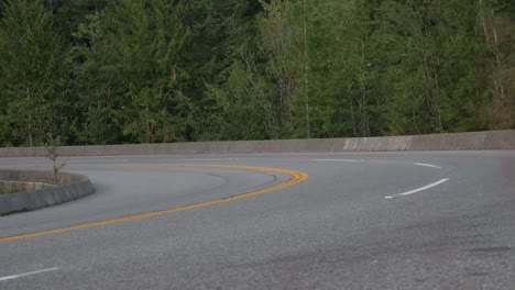 motorcyclist knee dragging on winding mountain road. wide