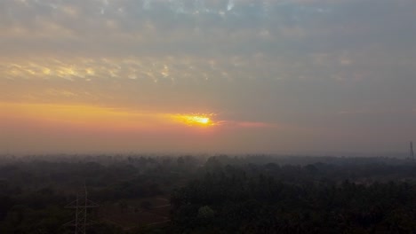 Aerial-view-over-a-misty-forest-in-sunset-light