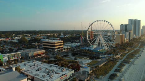 toma amplia de paralaje aéreo de skywheel en myrtle beach durante la hora dorada