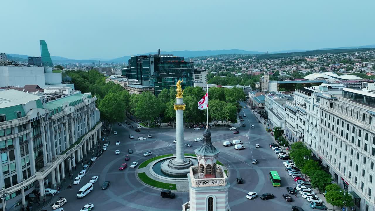 drone filmado para la plaza de la libertad en tbilisi, georgia, por la tarde antes de la puesta del sol al final de la primavera y el comienzo del verano cuando los árboles se ven verdes