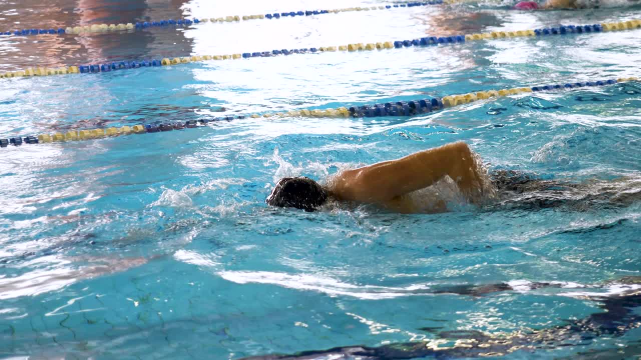 실내 수영장 에서 수영 하는 사람 들