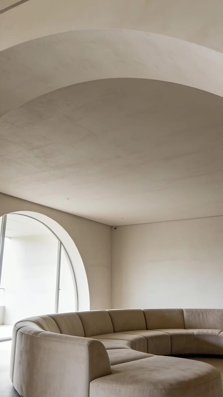 Video verticale: La telecamera si inclina e panoramica, mostrando un soffitto a volta, una finestra e un divano curvo in una stanza.