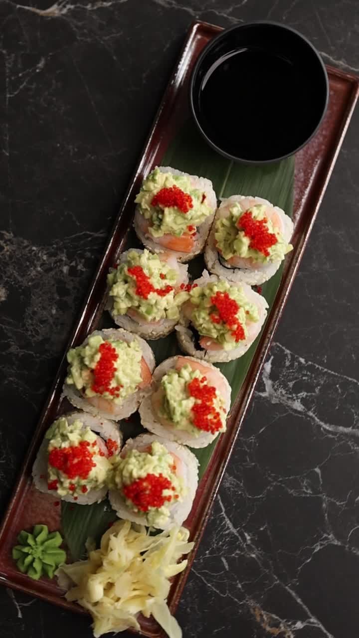 Sushi roll giapponesi con avocado e caviale rosso su un piatto