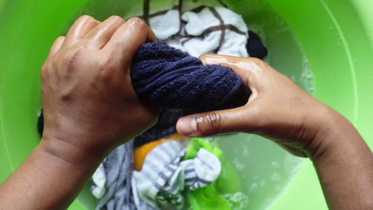 mujer lavando ropa en un lavabo