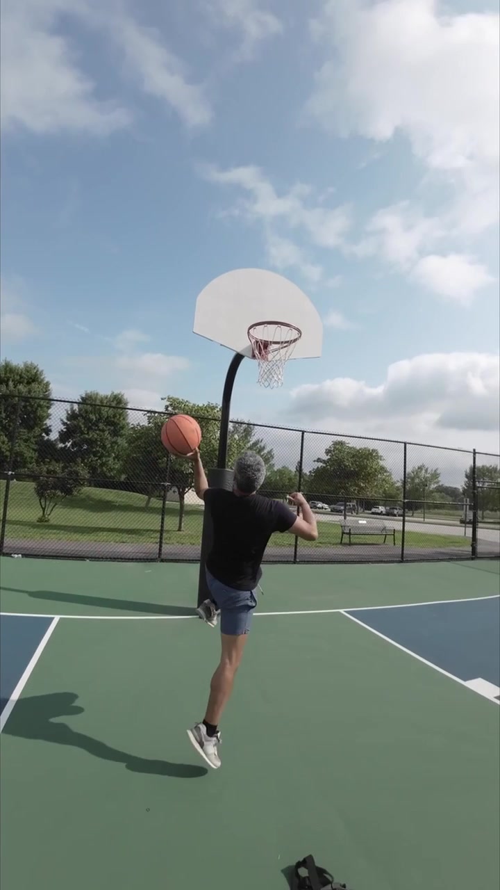 Uomo che si allena a tirare a basket su un campo all'aperto