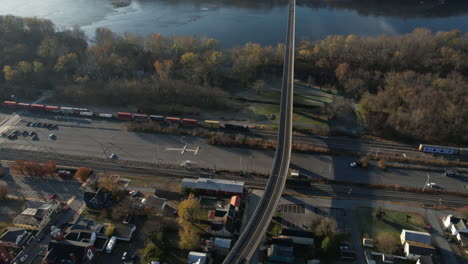 Vista-Aérea-Del-Tren-De-Carga-En-El-Ferrocarril-De-Baltimore-Ohio-Por-Brunswick-Y-El-Río-Potomac,-Maryland-En-El-Soleado-Día-De-Otoño,-Disparo-De-Drones