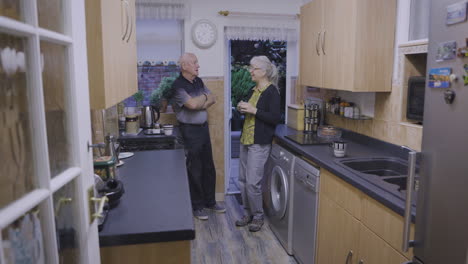 elderly couple conversing in kitchen