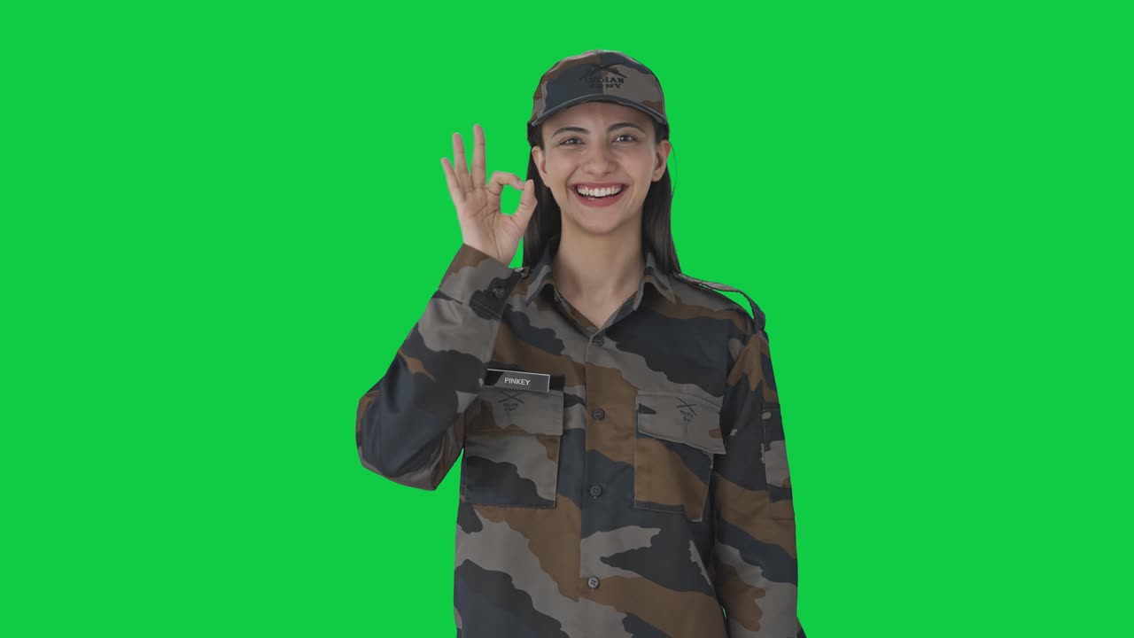 Happy Indian woman army officer showing okay sign Green screen