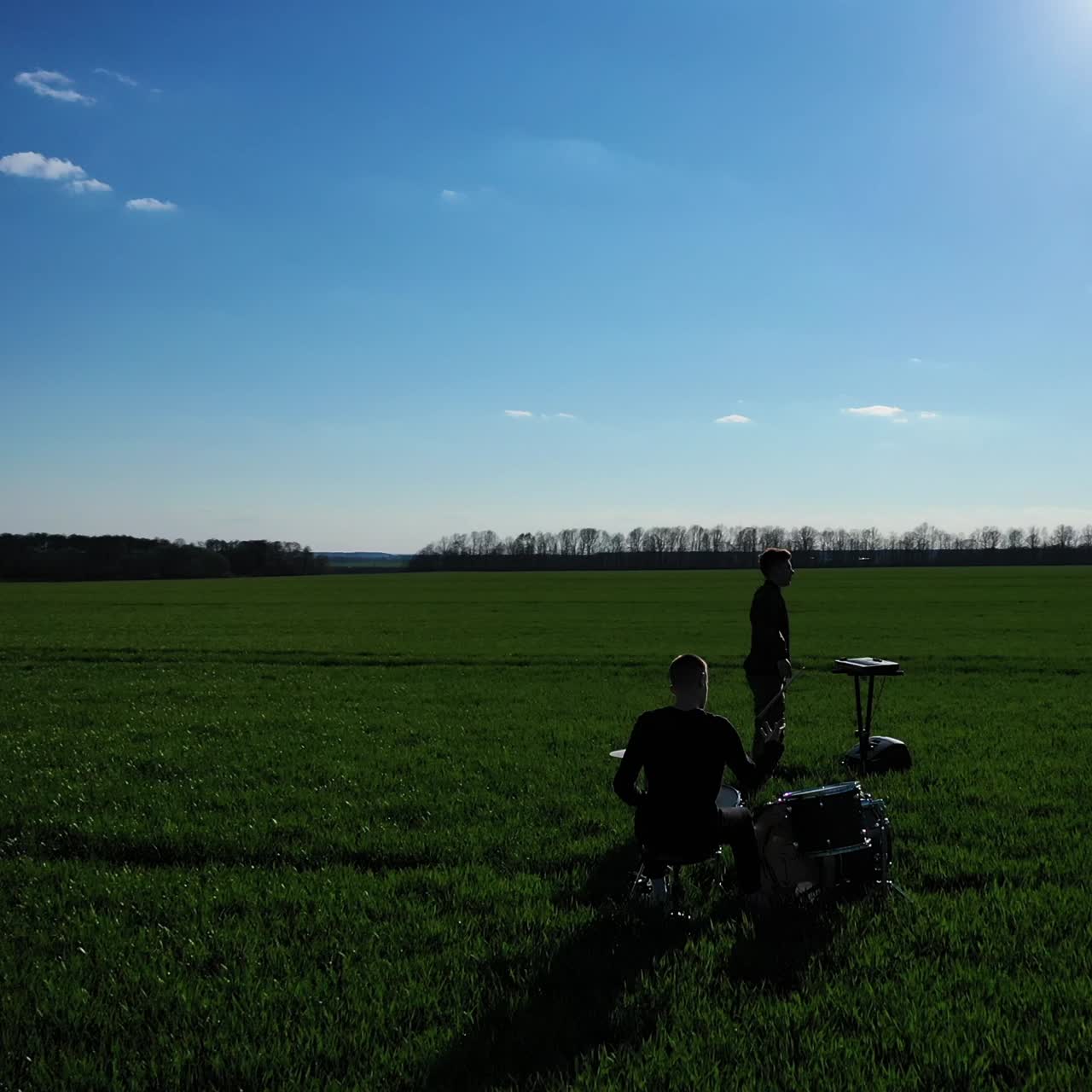 Musical performance in the green field on sunny spring day. Circle movement footage around group of musicians. Nature background