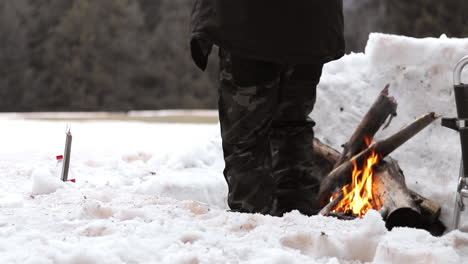 Aufnahme-Eines-Mannes,-Der-In-Einem-Kleinen-Iglu-In-Den-Bergen-Ein-Lagerfeuer-Bereitet