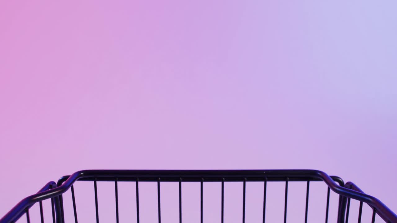 네온 보라색 배경 위에 복사 공간을 가진 쇼핑 트롤리의 비디오