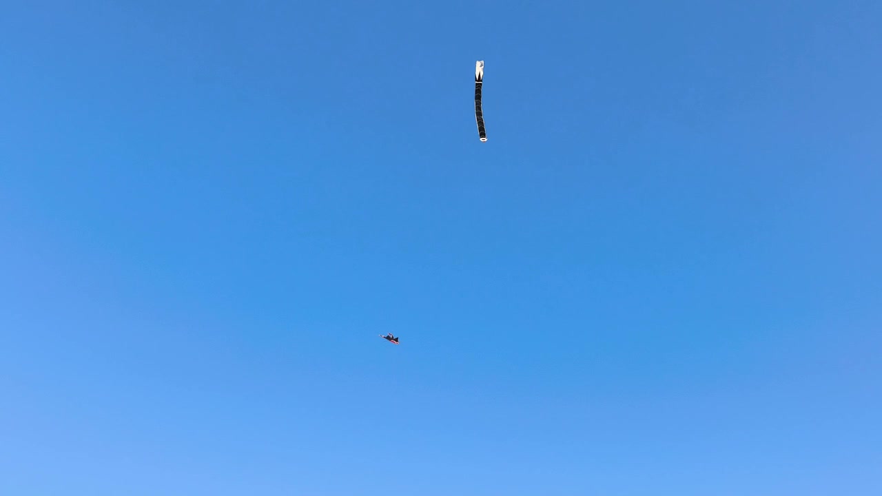 Two colorful kites flying high above Sanur Beach Bali against a clear blue sky creating a peaceful tropical holiday atmosphere