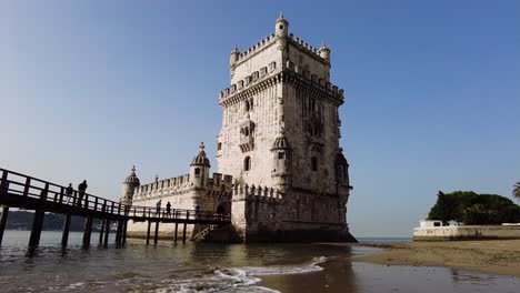 people at the bridge over the tagus river in torre de belem in lisbon, portugal