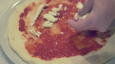 Señora-Preparando-Una-Pizza-Margherita-Con-Queso-Mozzarella-Fresco,-Salsa-De-Tomate-Y-Albahaca