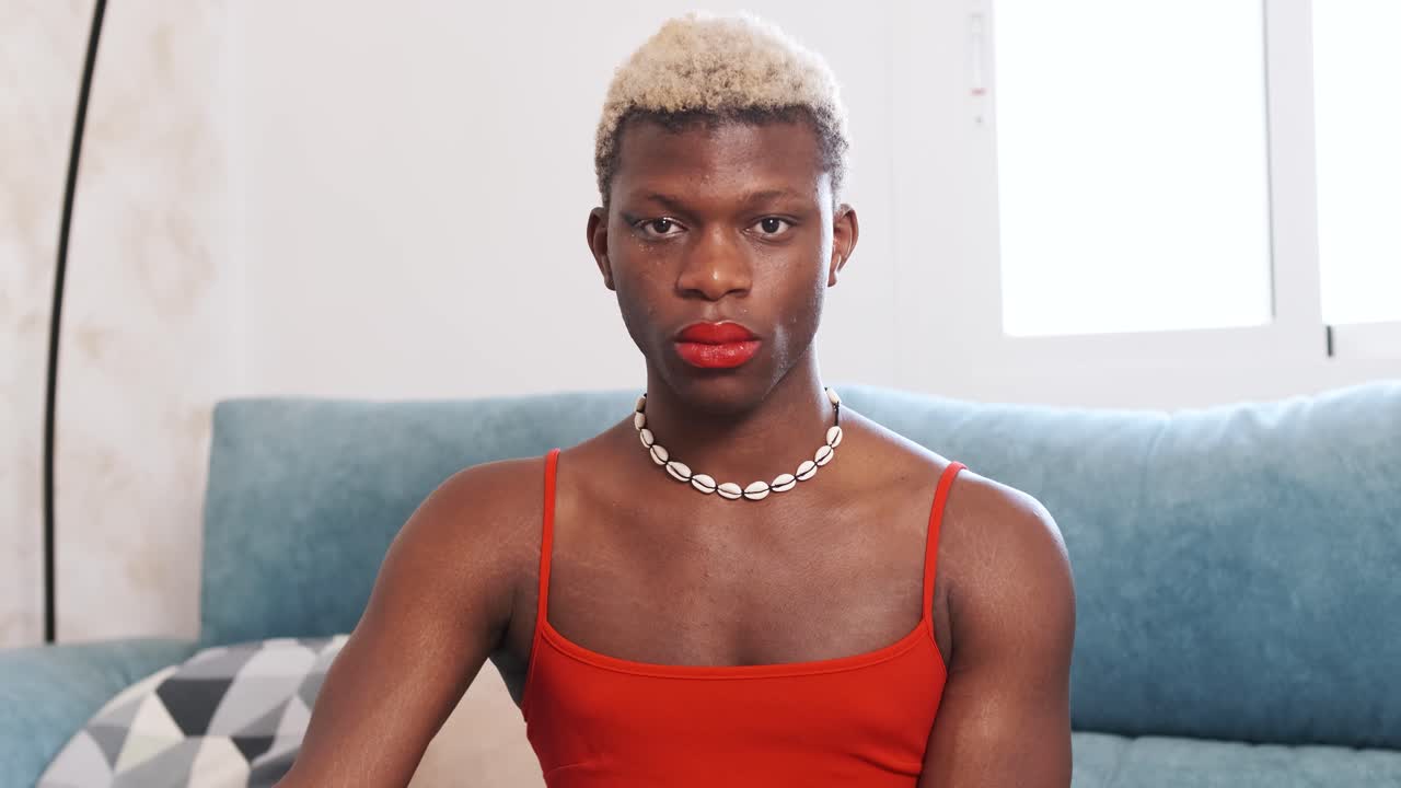 A person with blonde hair and red lipstick looking at the camera.