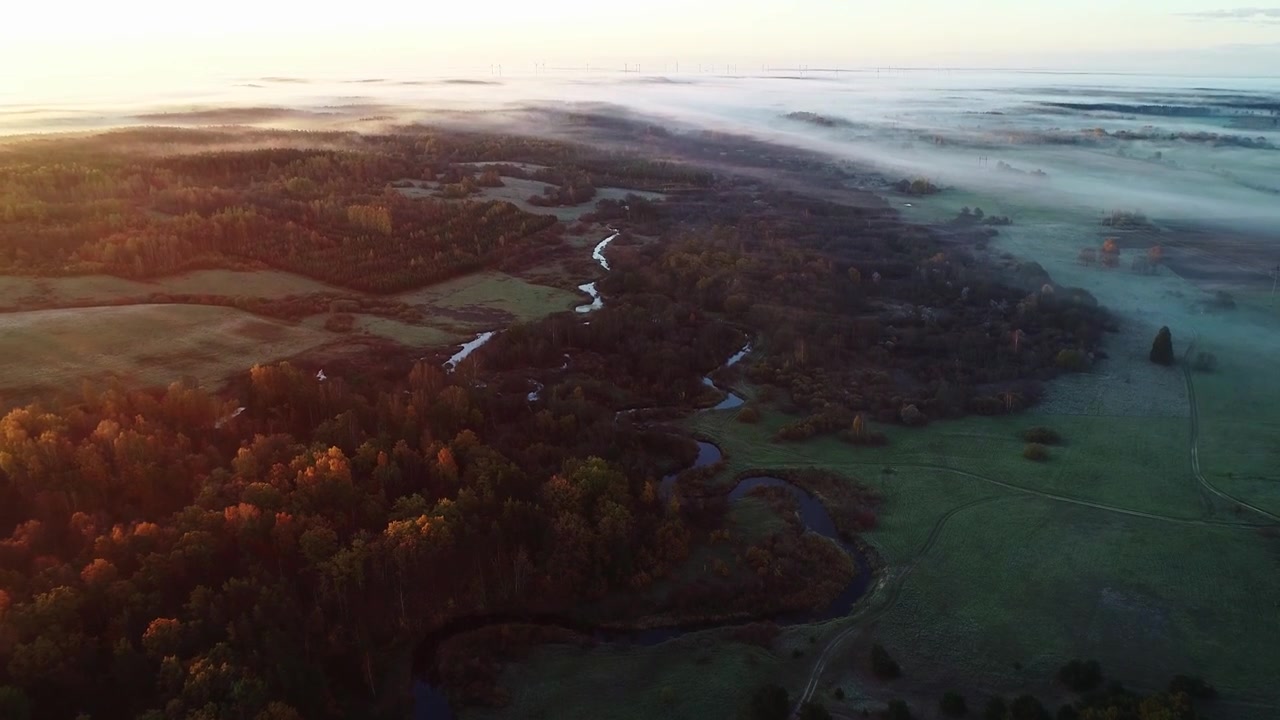 Gylden tåge over Sventaja-flodens slyngninger i Rucavas landskab
