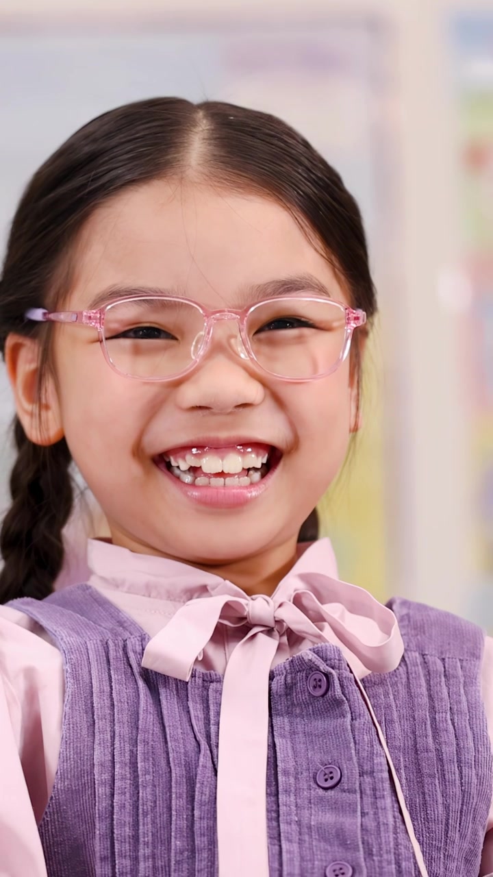 Close-up of a cheerful student laughing and clapping hands during a fun school lesson