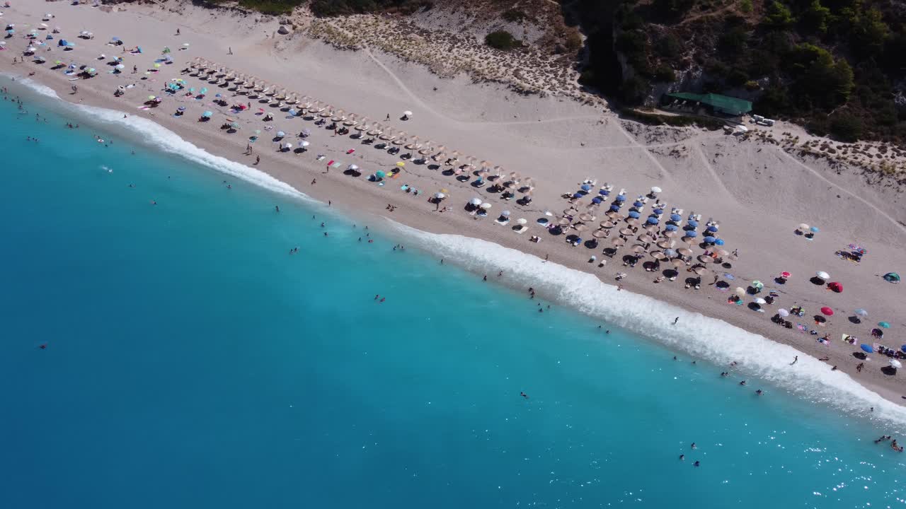 An aerial drone shot capturing Milos Beach on the Greek Island of Lefkada. Stunning sandy beach washed by crystal-clear water. D-Log M